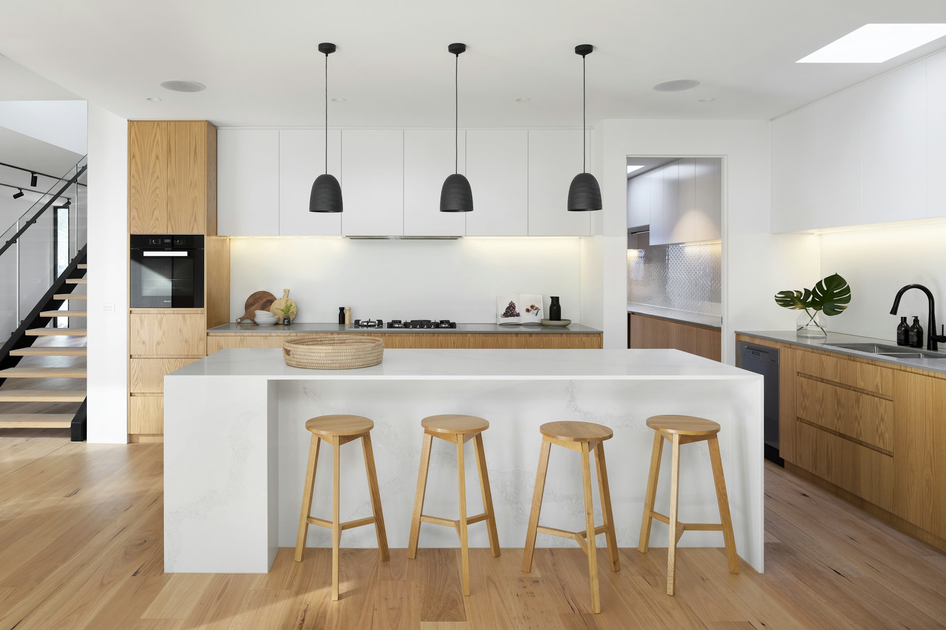 Eikenhouten en witte keuken met marmeren waterval kookeiland